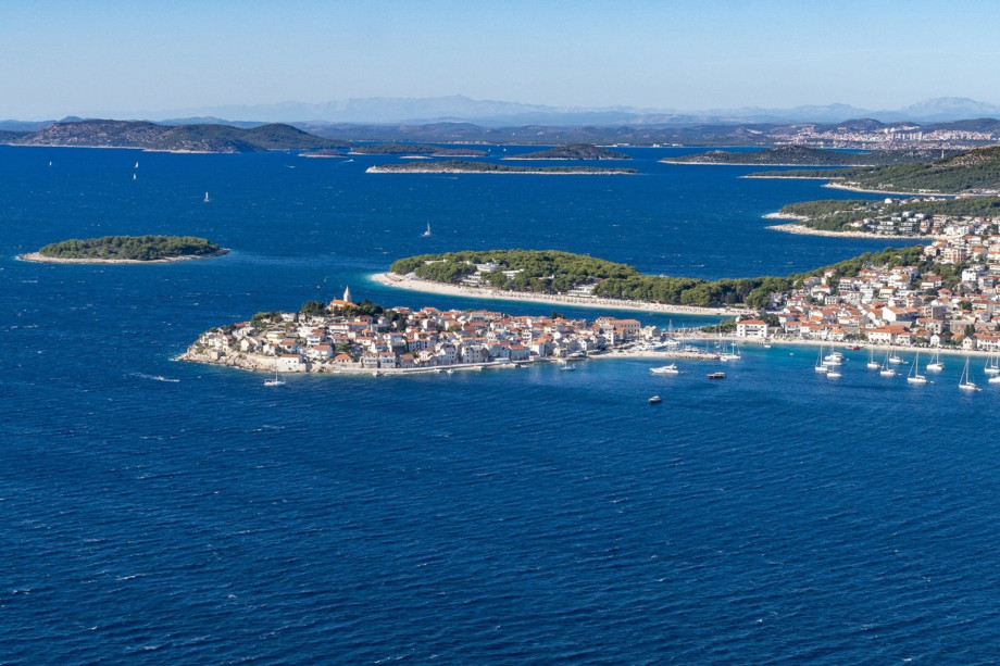 The picturesque old town of Primošten (17 km) is seen from a distance, surrounded by the deep blue Adriatic, showcasing its unique island-like charm.