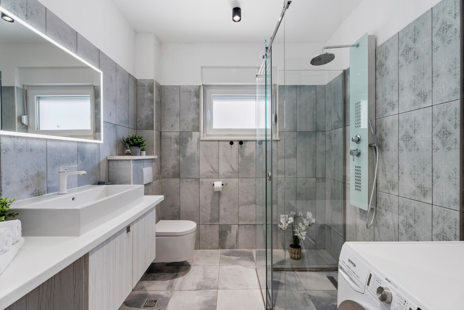 A family bathroom with a shower and a washing machine