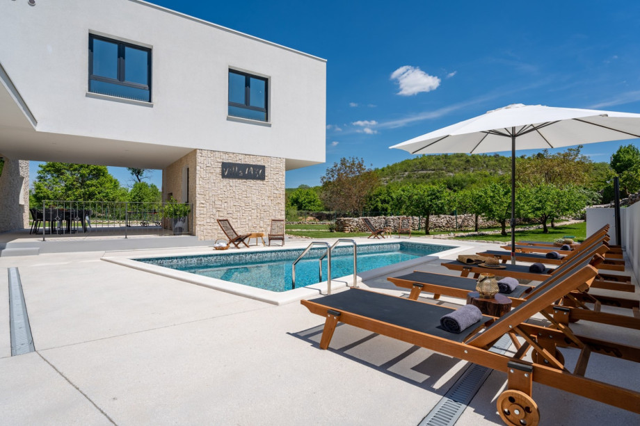 sun deck area with 6 deck chairs, covered outdoor dining area with TV and BBQ