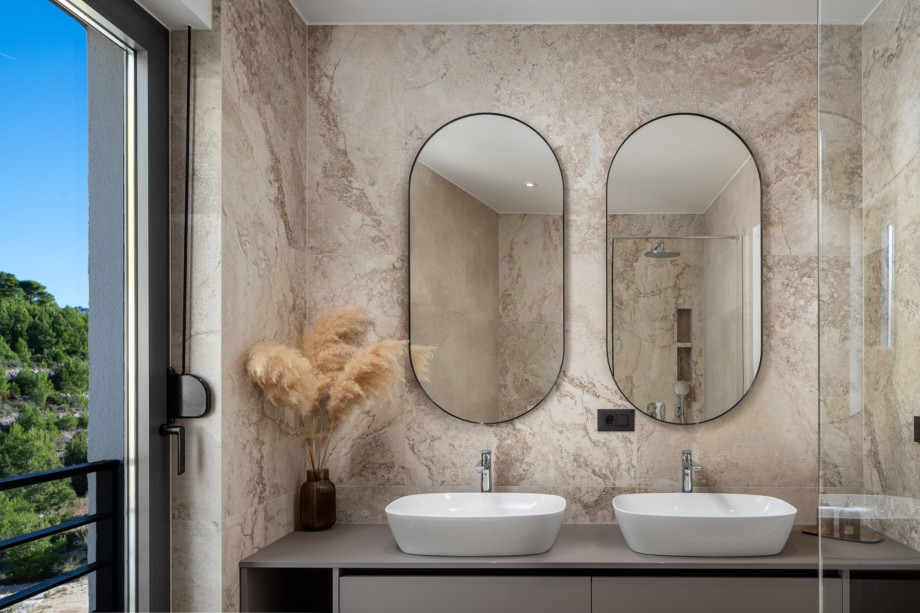 A family bathroom with a shower and two sinks, used by Bedrooms No2 and No3.