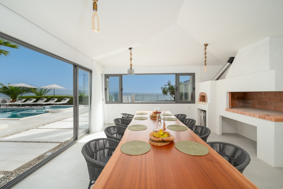 The covered outdoor area is a true oasis, complete with pool overlooking the azure sea