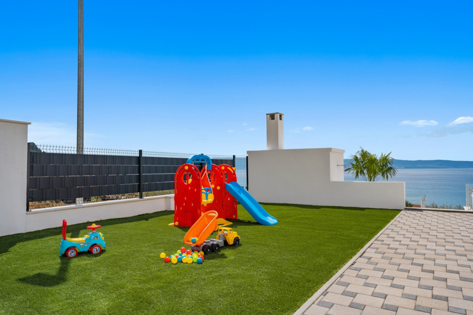 Playground for your youngest with some toys, swings, and a slide.