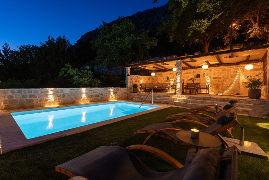 Enjoy the 20 sqm pool and a children's play area with a tent and pillows in a serene natural setting.