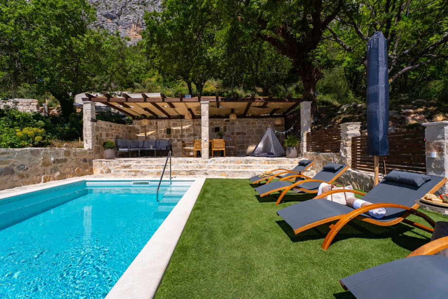 This outdoor oasis includes 4 comfortable deck chairs and a sun umbrella beside the 20 sqm pool.