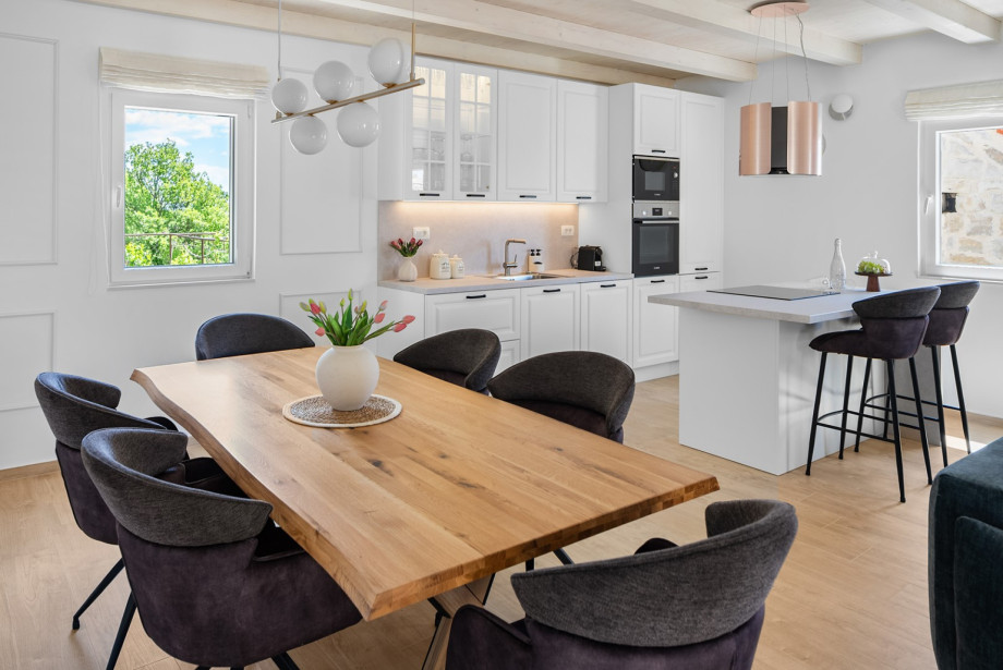 A spacious dining area includes a large table that comfortably seats up to 6 guests.
