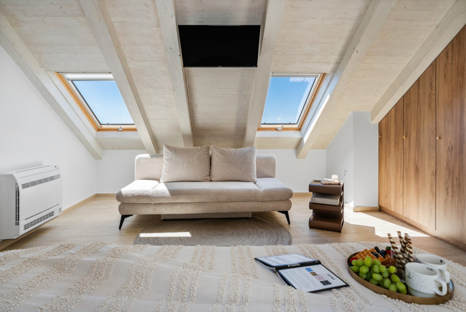 The attic bedroom offers air conditioning, a TV, and a sofa that converts into an extra bed.