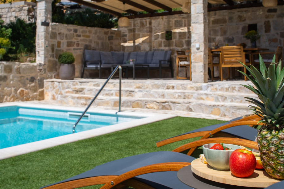 Relax on the deck chairs by the private pool in this serene natural setting.