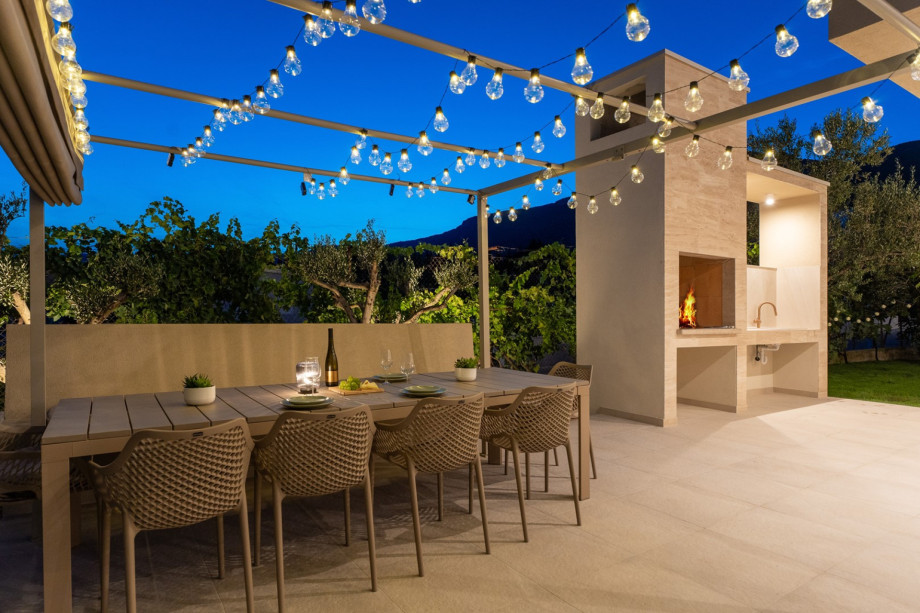 A shaded outdoor dining area with ambient lighting