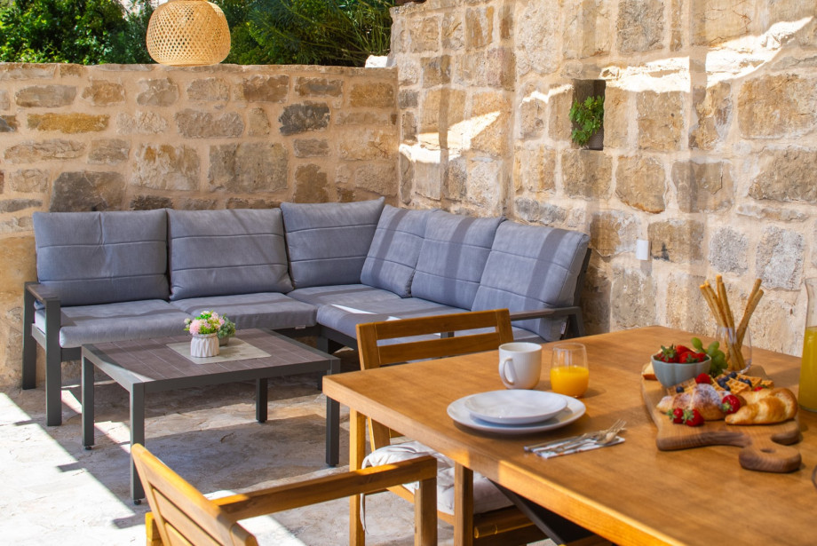 Relax in the cozy outdoor lounge corner, perfect for enjoying the serene Mediterranean surroundings.