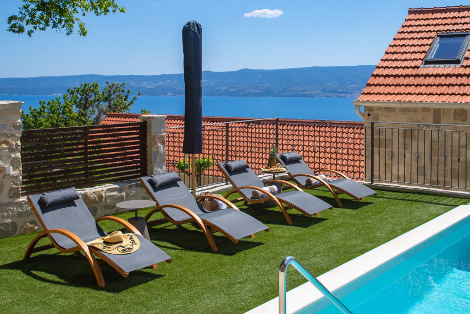 The private pool and sun umbrella offer a perfect spot to enjoy the stunning partial sea views.