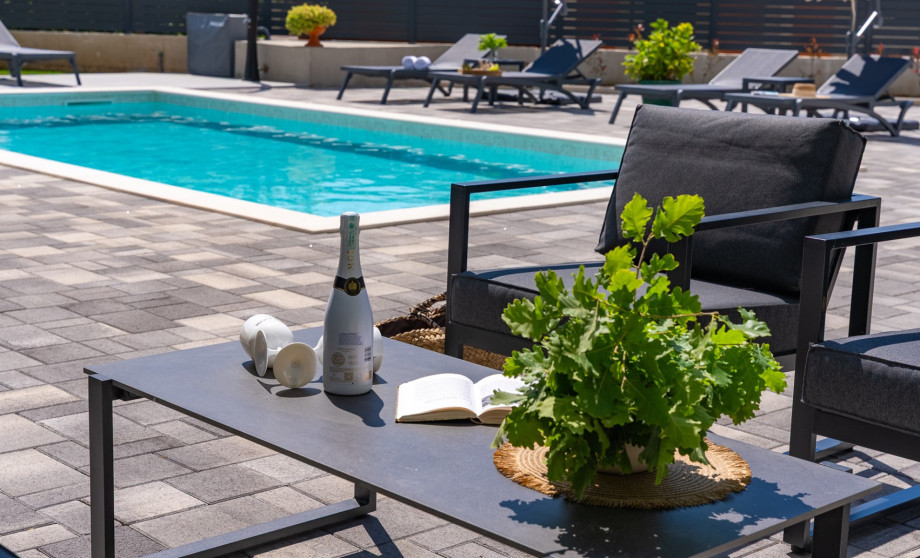 Genießen Sie die Lounge-Ecke direkt neben dem 32 m2 großen beheizten Pool.