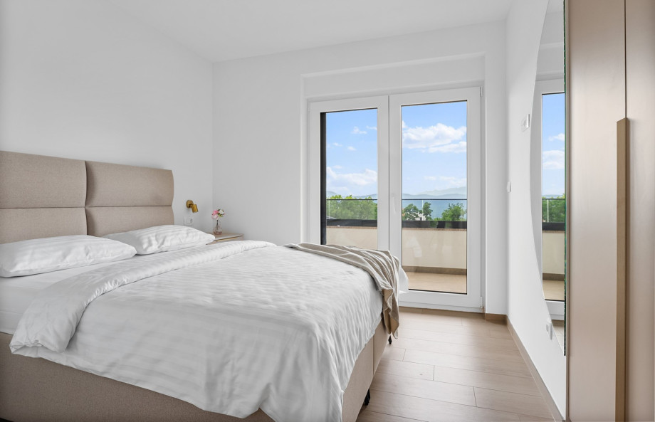 Schlafzimmer 2 bietet ein Queen-Size-Bett, eine Klimaanlage und einen Balkon.