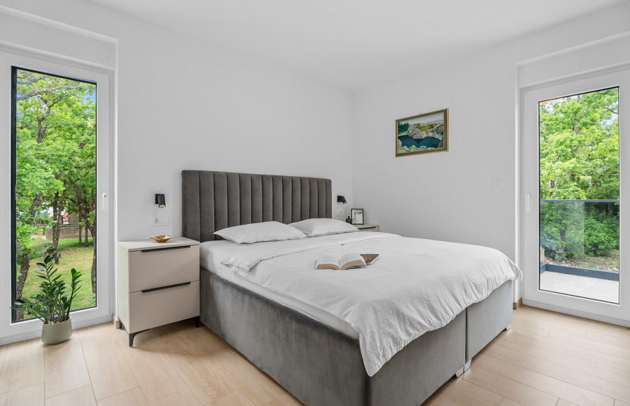 Schlafzimmer 4 verfügt über ein King-Size-Bett und bietet einen Blick auf die natürliche Umgebung.