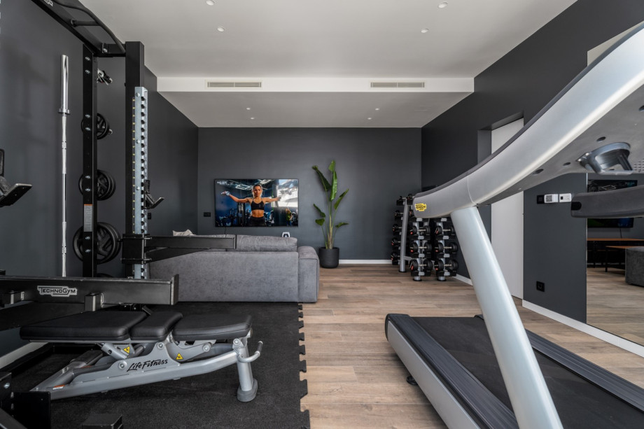 Spielzone mit einem Sofa mit Flachbildfernseher mit PlayStation 5 für jüngere Generationen.