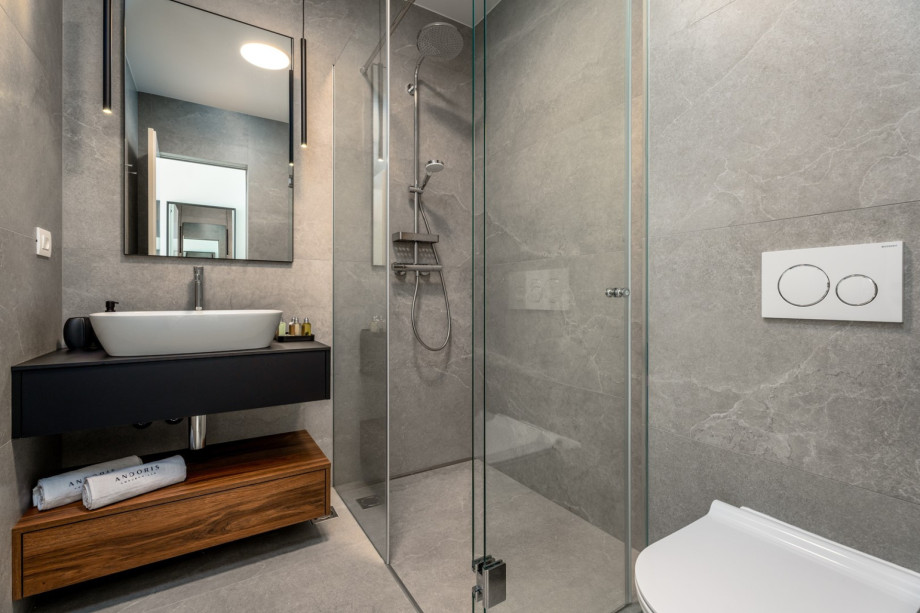 En-suite Badezimmer mit Dusche und Ausgang zum Poolbereich.