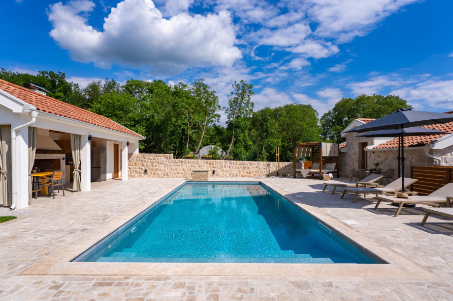 A spacious sundeck area includes 8 deck chairs, a double sunbed, and an outdoor shower.
