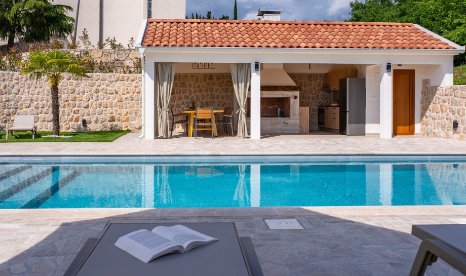 The fully equipped summer kitchen has a barbecue, refrigerator and a dining table for 8 people.