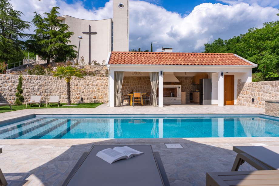 The fully equipped summer kitchen has a barbecue, refrigerator and a dining table for 8 people.