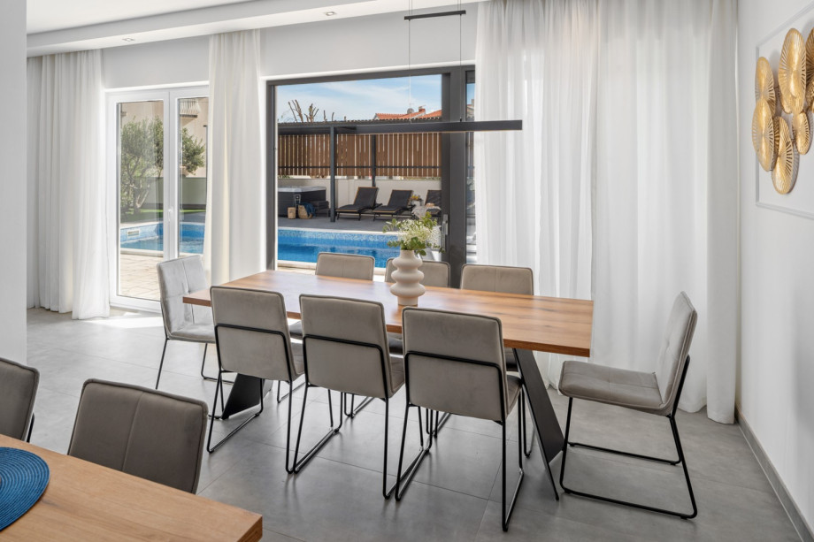 The ground floor floor (pool level) offers a fully air-conditioned, open-plan living and dining area