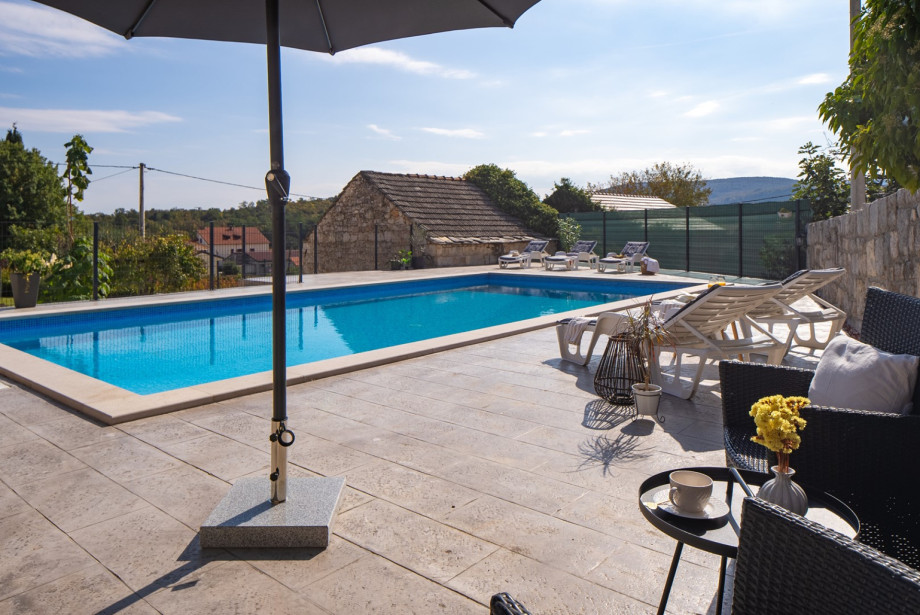 The spacious sun deck features 8 deck chairs and a cosy lounge area, providing space for guests to bask in the sun by the pool.