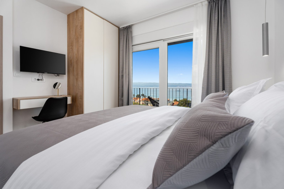Schlafzimmer NO2, Fernseher, Klimaanlage, Balkon und Blick auf das Meer und den Pool
