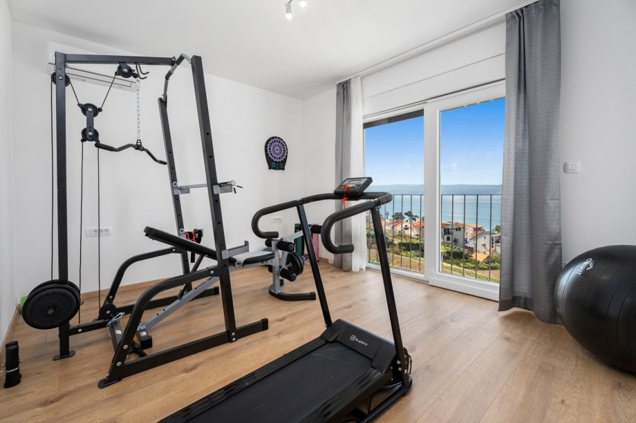 Fitnessstudio mit Laufband, multifunktionalem Trainingsgerät, Yogamatte und Pilatesball
