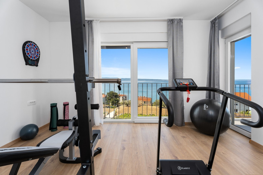 Fitnessraum mit Fernseher, Klimaanlage und Balkon
