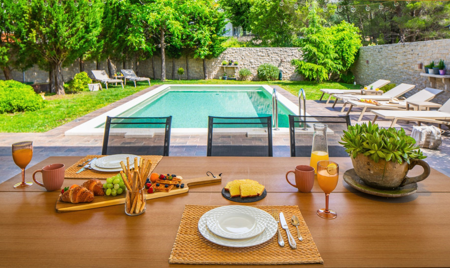 Large covered dining area with pool view.