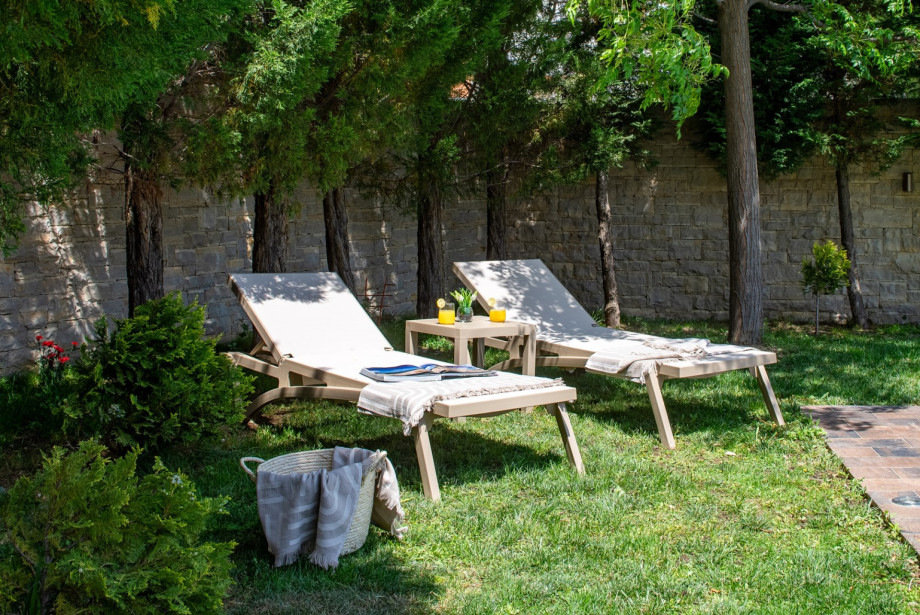 Peaceful garden setting with sun loungers.