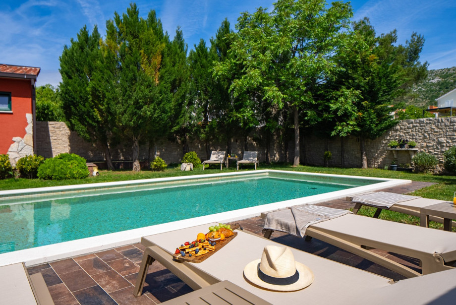 Sun deck area with 6 deck chairs surrounded by lush greenery.