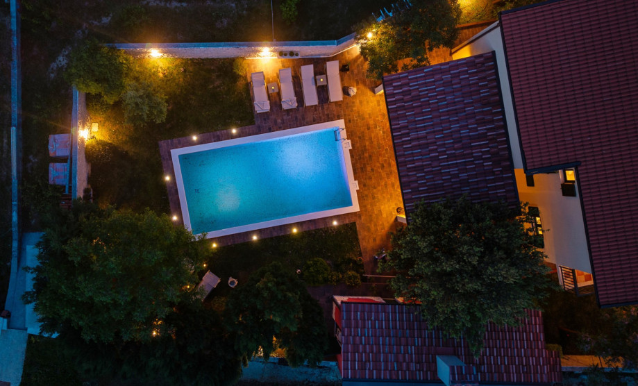 A charming two-level villa featuring a private heated pool and lush green garden.