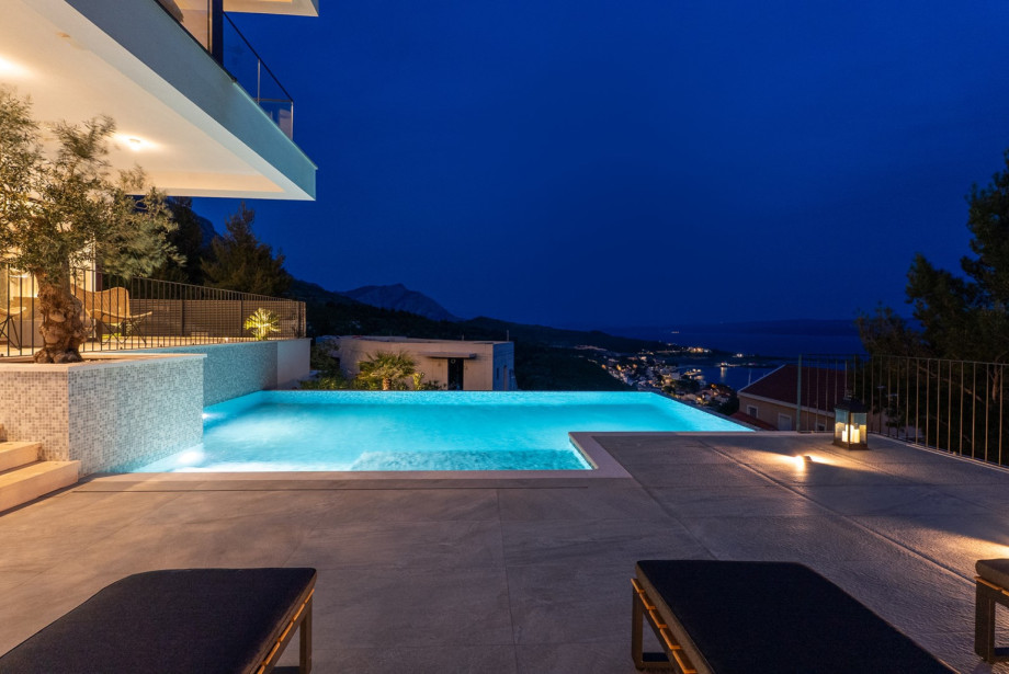 Private heated swimming pool, which measures 9.5m x 4.5m and includes a sitting bench and hydromassage feature