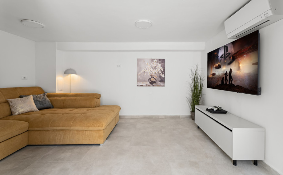 Media room is equipped with a comfortable sofa, smart TV, and PlayStation 4