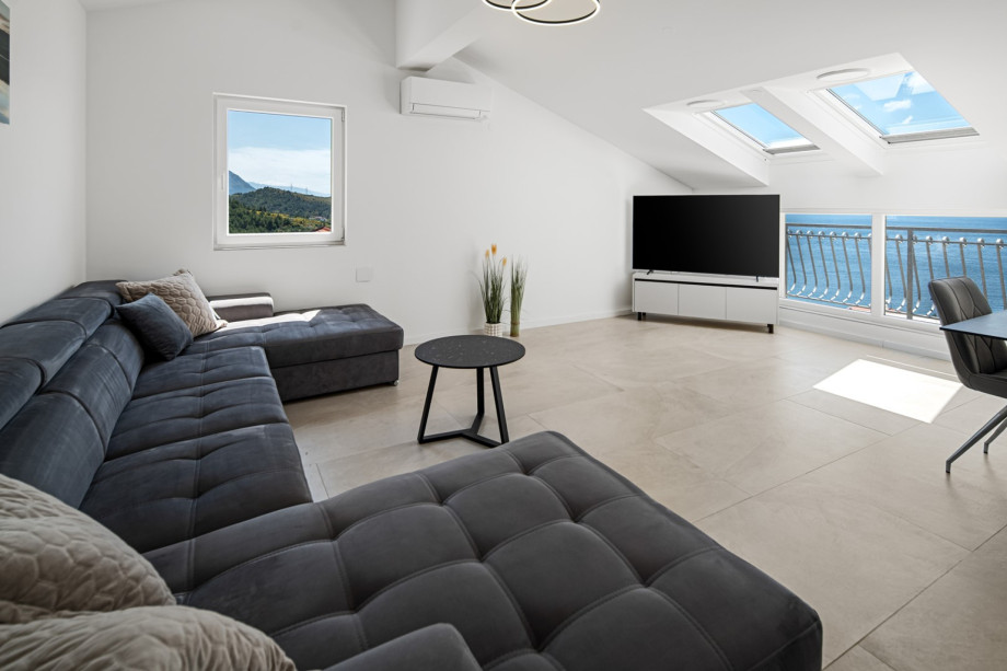 Second floor with an open-concept living area that opens to a balcony with stunning sea views