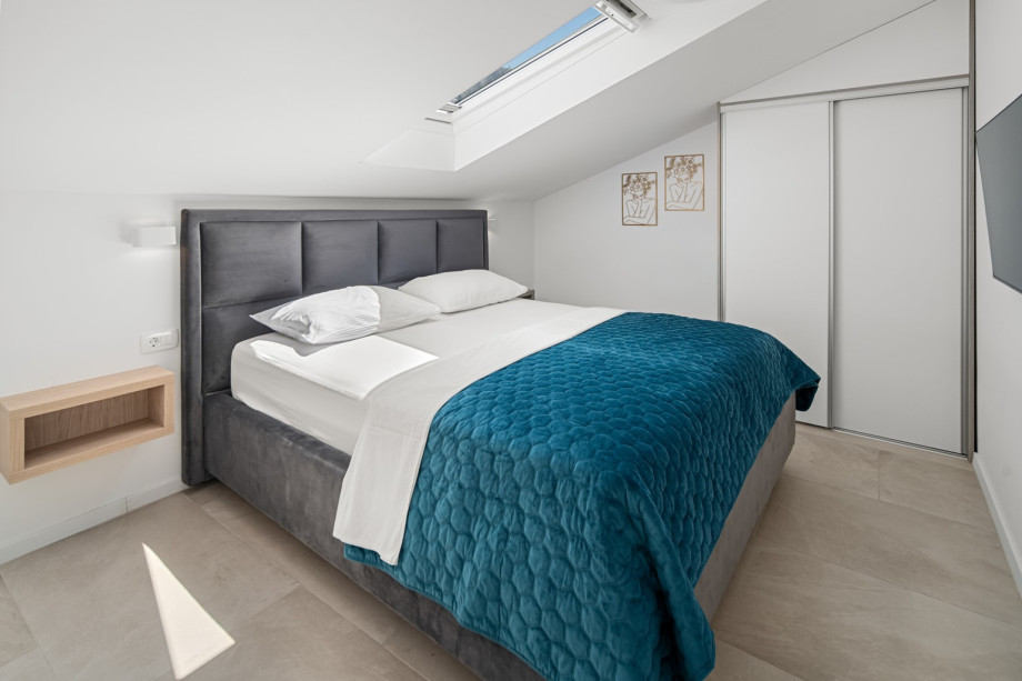 Bedroom 1 (12 sqm) with a king-size bed (180 cm x 200 cm), TV, and A/C