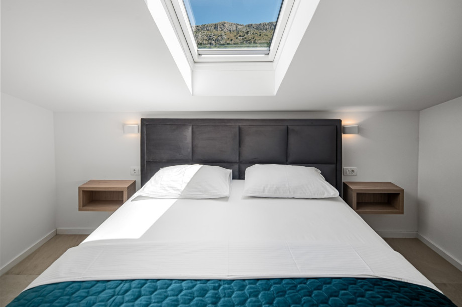 Bedroom 1 (12 sqm) with a king-size bed (180 cm x 200 cm), TV, and A/C