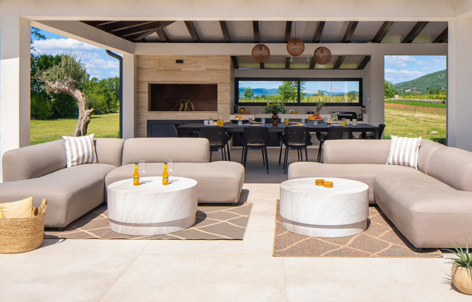 Relax in the outdoor sofa area with a refreshing drink, perfect for unwinding in the afternoon sun