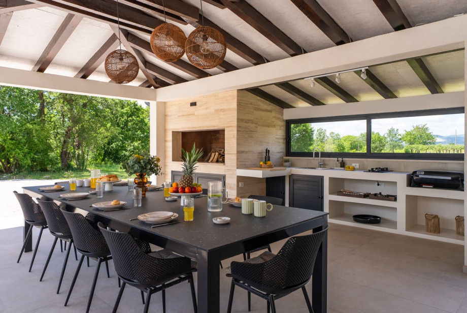 A covered dining area with a barbecue (wood and charcoal) allows for delightful al fresco meals
