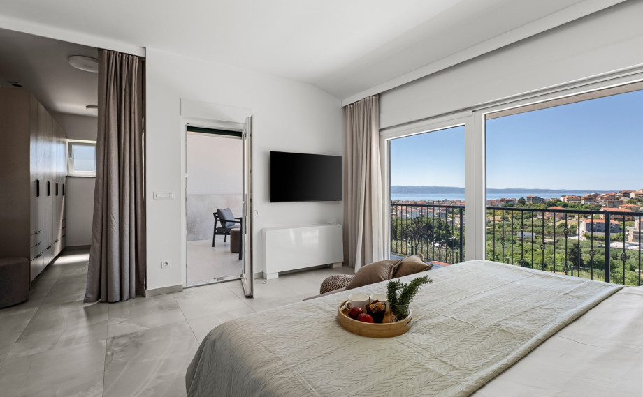 The master bedroom also offers a TV, air conditioning, an en-suite bathroom with a shower, and a walk-in wardrobe