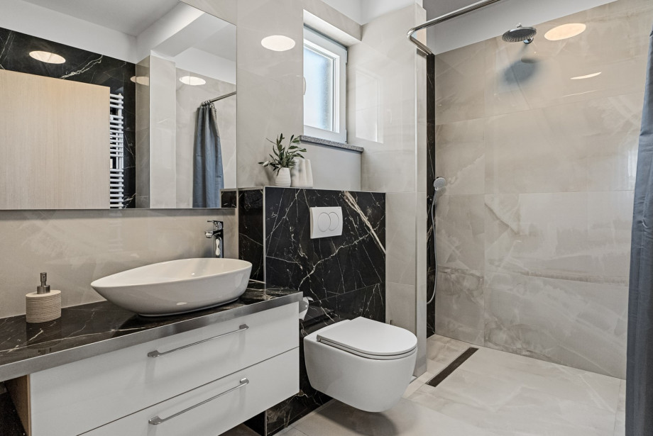 An en-suite bathroom with a shower, a sink, and a toilet