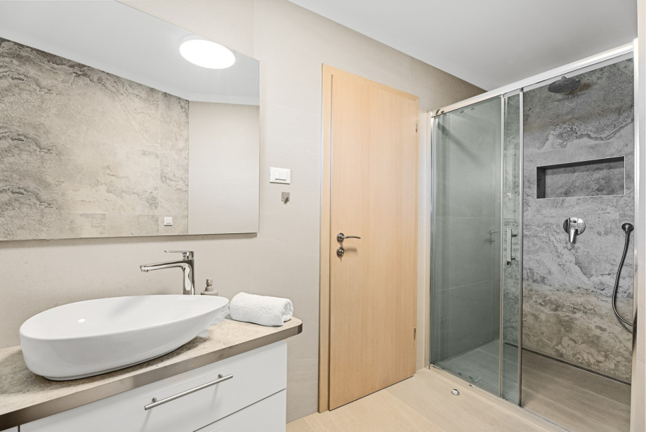 An en-suite bathroom with a shower, a sink, and a toilet