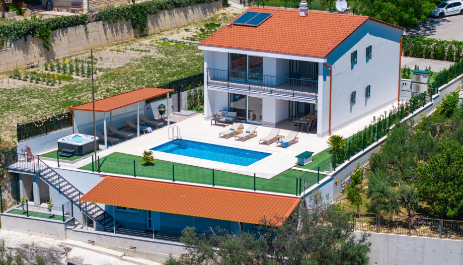 The property is fully fenced and provides four private parking spaces, making it ideal for those traveling by car