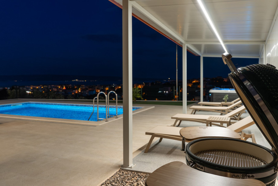 A spacious terrace with outdoor furniture offers amazing sea and pool views