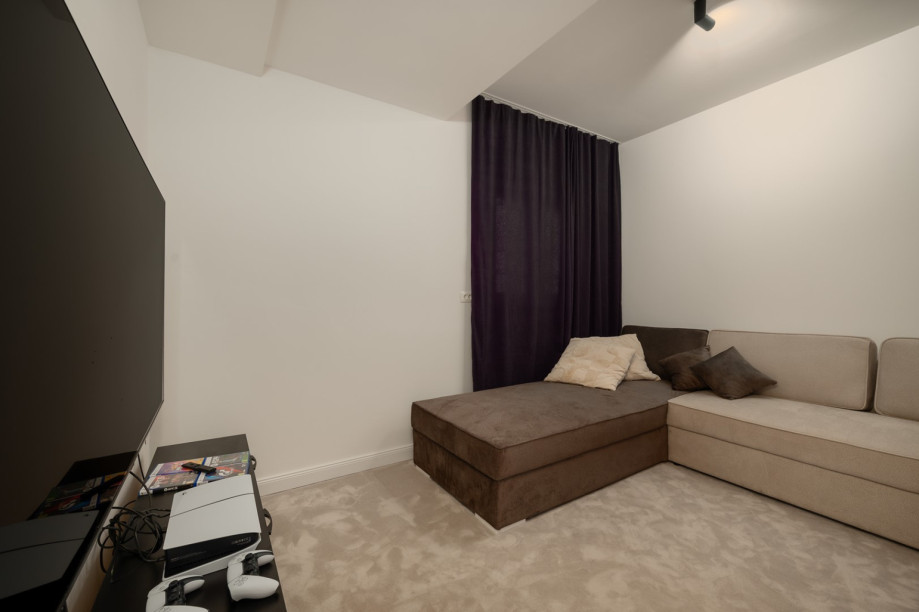 Es gibt auch einen Medienraum (13,2 m2) mit einem Sofa und einer PlayStation 5