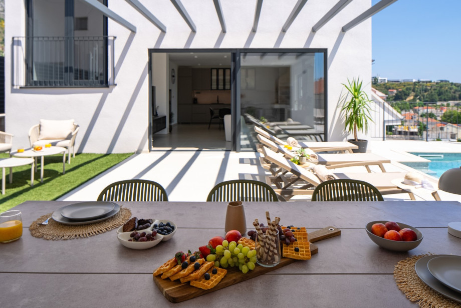 Large sliding doors create a seamless flow between the indoor living area and the outdoor pool.