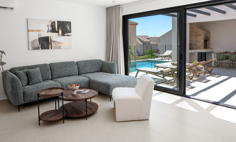Relax on the comfortable sofa in the air-conditioned living room with direct access to the pool.