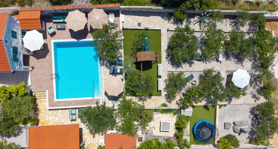 The private garden offers olive trees, reading spots, and a play area.