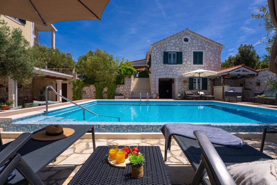The pool deck is equipped with lounge chairs and an outdoor shower.
