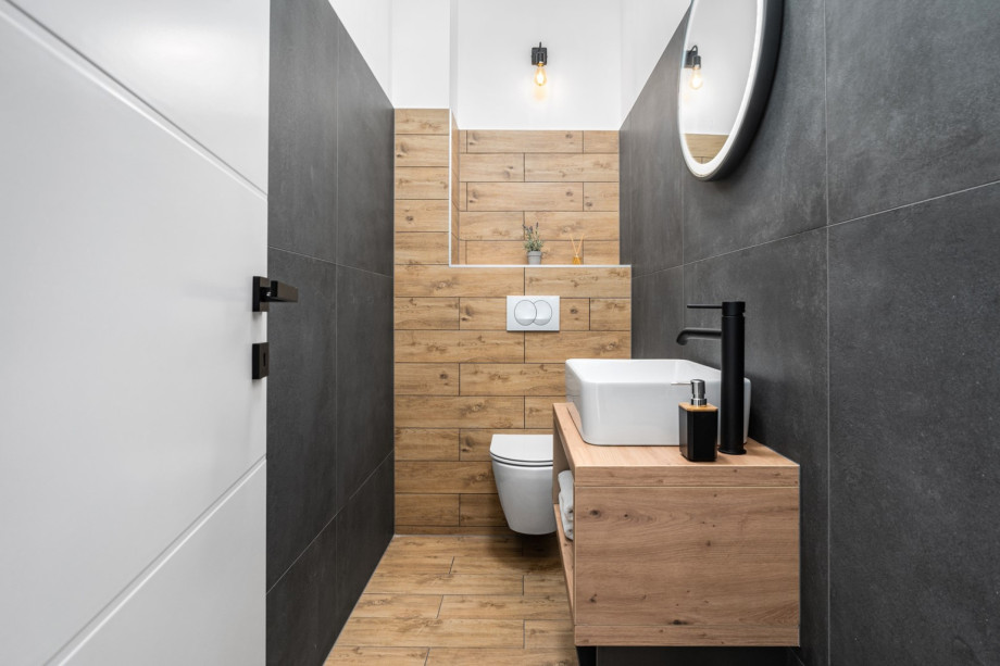 Separate toilet, and a laundery room with a washing machine, a dryer and ironing amenities