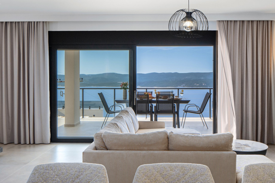 The living room features glass walls that allow for beautiful views and ample daylight